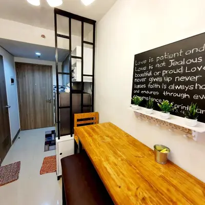 a wooden table in a room with a sign on the wall at S Residences MOA Condo Stunning Boutique Hotel Type T1 in Manila