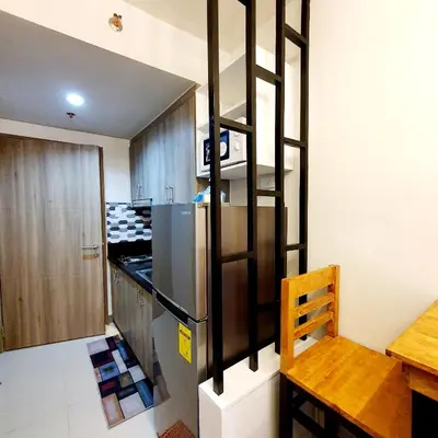 a kitchen with a refrigerator and a table and a chair at S Residences MOA Condo Stunning Boutique Hotel Type T1 in Manila