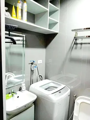 a bathroom with a washing machine and a sink at Air Residences Makati Condo Elegant Grand Hotel Type in Manila