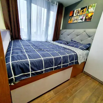 a bedroom with a bed with a blue comforter and a window at Air Residences Makati Condo Elegant Grand Hotel Type in Manila