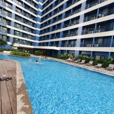 a swimming pool in front of a large building at Air Residences Makati Condo Elegant Grand Hotel Type in Manila