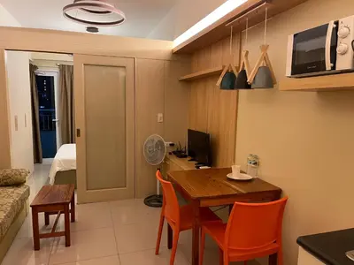 a kitchen and dining room with a table and chairs at Netflix- Destina Stays at Jazz Residences Makati, MetroManila in Manila