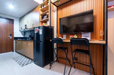 a kitchen with a black refrigerator and a bar with stools at Shell Residences Pasay 1BR Walk to MOA Newly Renovated! in Manila