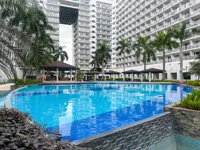 a large swimming pool in front of a large building at Shell Residences Pasay 1BR Walk to MOA Newly Renovated! in Manila
