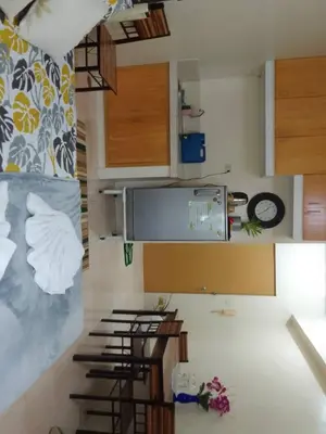 a kitchen with wooden cabinets and a counter top at Aliyahs Place in Cainta