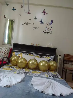 a bed with a large gold balloon on it at Aliyahs Place in Cainta