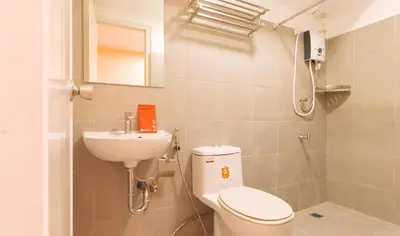a small bathroom with a toilet and a sink at RedDoorz Plus @ Kaizen Suites Taft Avenue in Manila
