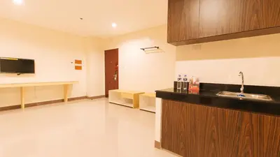 a room with a kitchen with a sink and a tv at RedDoorz Plus @ Kaizen Suites Taft Avenue in Manila