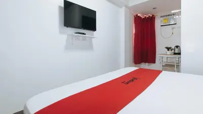 a bedroom with a white bed with a red blanket at RedDoorz near UST Sampaloc Manila in Manila