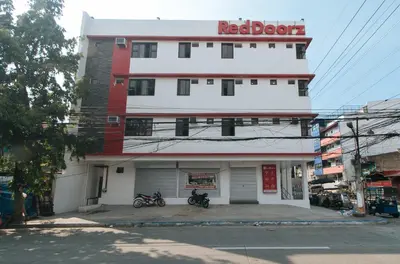 a red block building with motorcycles parked in front of it at RedDoorz near UST Sampaloc Manila in Manila