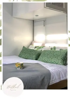 two beds with green and white pillows in a room at Bethel House in Manila