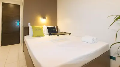 a white bed in a room with a table on it at UrbanView at San Antonios Place Sampaloc Manila in Manila