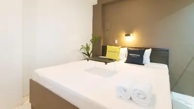 a bedroom with a bed with a laptop on it at UrbanView at San Antonios Place Sampaloc Manila in Manila