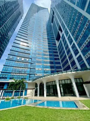 a tall building with a pool in front of it at 1BR executive unit in Uptown Parksuites BGC in Manila
