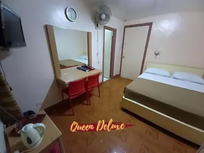 a bedroom with a bed and a desk and a mirror at BEST FORTUNE HOTEL at CHINATOWN in Manila