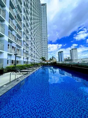 a large swimming pool next to a tall building at Coast Residences, Roxas Blvd, Pasay City in Manila