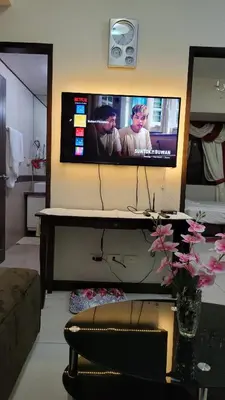a living room with a flat screen tv on the wall at MANILABAY HOME in Manila