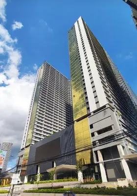 a tall building with two tall buildings at Cozy Bedroom FAME Condo Greenfield EDSA MRT Shaw in Manila