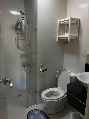 a bathroom with a shower and a toilet and a sink at S&S CondoTel STUDIO TYPE One Palm Tree Villas in Manila