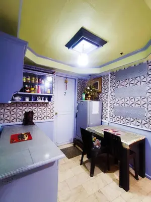a kitchen with a table and a refrigerator at City Tower Condominium Transient Inn in Manila