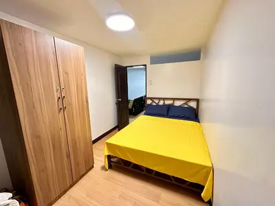 a bedroom with a yellow bed in a room at Fetalino's Place Imus in Imus