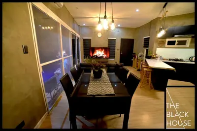 a living room with a table and a fireplace at The Black House in Dulong Bayan