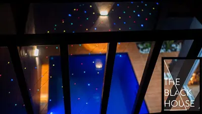 a window view of a black house with lights at The Black House in Dulong Bayan