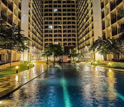 a wet street in a city at night with buildings at Shore Residence D3 Shortwalk mall of Asia near airport in Manila