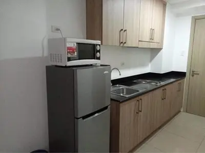 a kitchen with a microwave on top of a refrigerator at SHELL RESIDENCE C1 shortwalk MALL OF ASIA NEAR AIRPORT in Manila