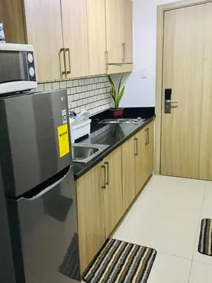 a small kitchen with a sink and a refrigerator at NJ's Place, Shore 1 Residences, MOA Complex, Pasay City, Philippines in Manila