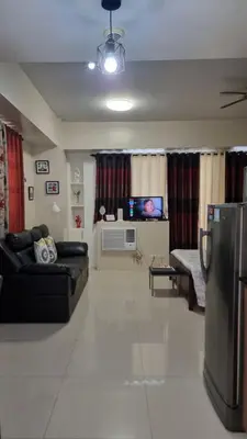 a living room with a couch and a tv at Condo Airport NAIA Terminal-3 One Palm Tree Villas in Manila