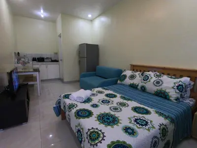 a small bedroom with a bed and a blue chair at South Breeze Balibago 3 minutes away from Santa Rosa Commercial Complex in Macabling