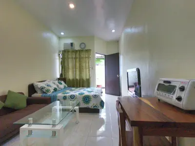 a living room with a couch and a bed at South Breeze Balibago 3 minutes away from Santa Rosa Commercial Complex in Macabling
