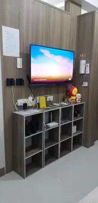 a tv on top of a wooden wall with a entertainment center at Jk Coastal Inn in Manila