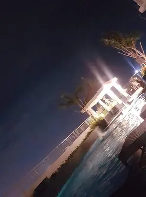 a night view of a building with a palm tree at Jk Coastal Inn in Manila