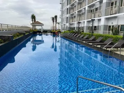 a large swimming pool in front of a building at Jk Coastal Inn in Manila