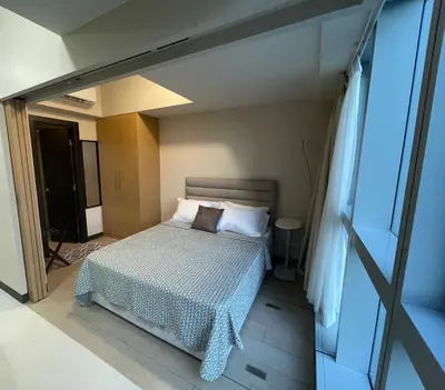 a bedroom with a bed and a window at 1 BR condo Uptown Parksuites BGC, high floor, morning sun in Manila