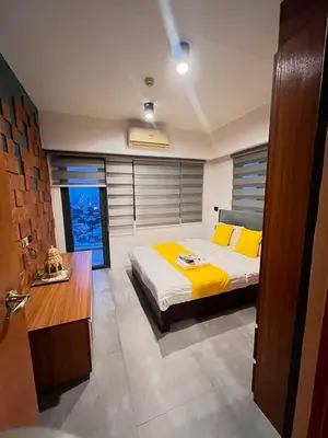 a bedroom with a large bed with yellow pillows at 1 bedroom Service Aprtmnt 2pax allows other 4pax 25011 in Cubao Quezon City in Manila