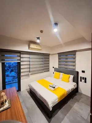 a bedroom with a large bed with yellow pillows at 1 bedroom Service Aprtmnt 2pax allows other 4pax 25011 in Cubao Quezon City in Manila