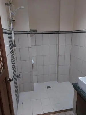 a bathroom with a shower and a sink at Makabata Guesthouse & Cafe in Manila