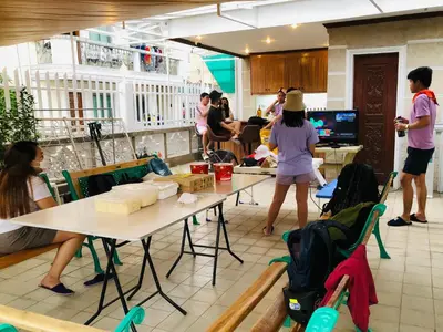 a group of people standing around a room with tables at THE MANSION- Near NAIA Airport Terminal PASAY in Manila