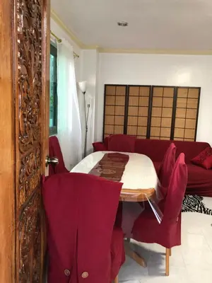 a living room with a table and a red couch at THE MANSION- Near NAIA Airport Terminal PASAY in Manila