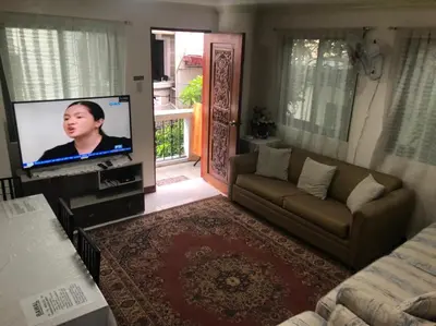 a living room with a couch and a flat screen tv at THE MANSION- Near NAIA Airport Terminal PASAY in Manila