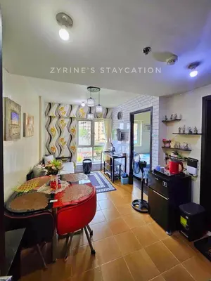 a living room with a table and a kitchen at The Rochester - Flat in Pasig near BGC in Manila