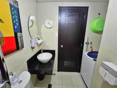a bathroom with a black door and a sink at The Rochester - Flat in Pasig near BGC in Manila