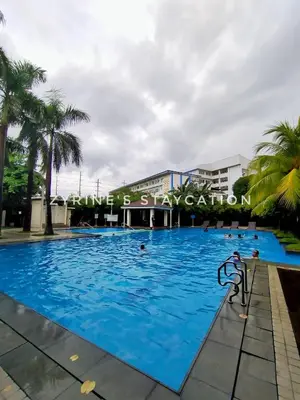 a large pool with blue water in front of a building at The Rochester - Flat in Pasig near BGC in Manila