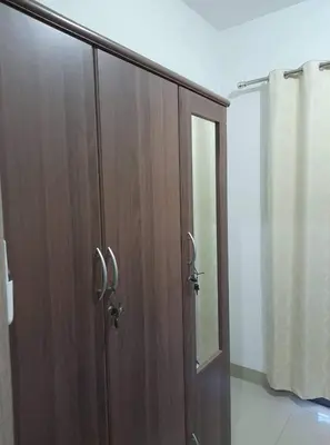 a wooden cabinet with a glass door in a room at Cozy 619 shore2 residence tower2 near MOA in Manila