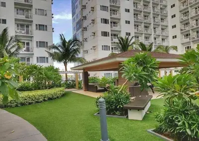 a garden with a bench and some buildings at Shore Residence D5 Shortwalk Mall of Asia, Near Airport in Manila