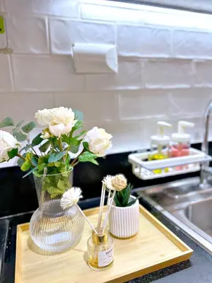 a vase of flowers on a cutting board on a kitchen counter at Cozypura Staycation near MOA, Airport , with free fast WIFI, Netflix and pay parking in Manila