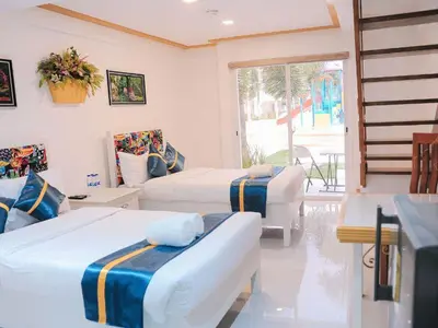 a hotel room with two beds and a window at Villa Excellance Beach and Wave Pool Resort in Postema